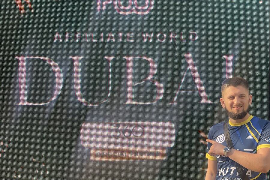 Esef Cosic beside a large LED wall reading Affiliate World Dubai.