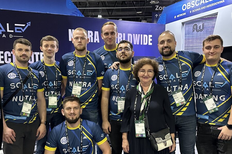 The Obscale team in branded kit in front of their exhibition stand, signed Obscale, Bosnia and Herzegovina.